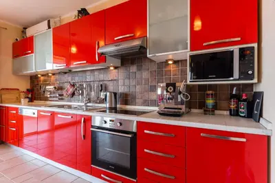 a red kitchen with red cabinets and a microwave at Montenegro Apartments Utjeha in Utjeha