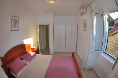 a bedroom with a bed with pink pillows and a window at Apartment Antonia in Kotor