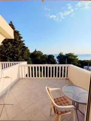 a balcony with a glass table and a chair at Joksimović apartmani in Bar, Susanj