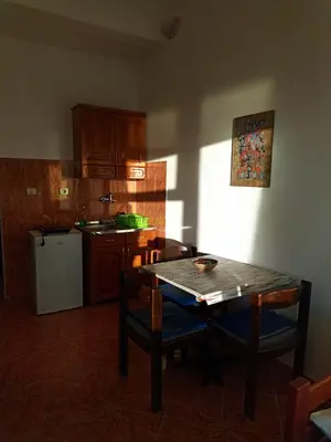 a kitchen with a table and a table and chairs at Joksimović apartmani in Bar, Susanj