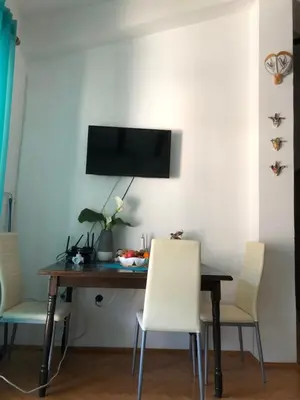 a dining room table with chairs and a television on a wall at Adok stan in Budva