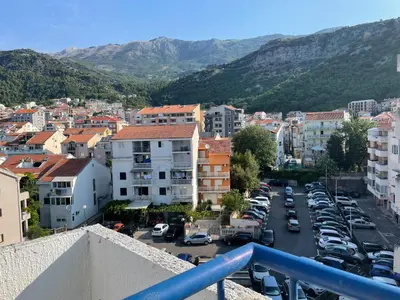a city with cars parked in a parking lot at Adok stan in Budva