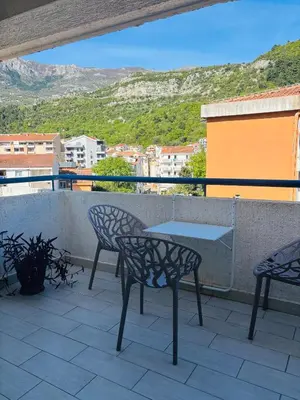 a patio with two chairs and a table on a balcony at Adok stan in Budva