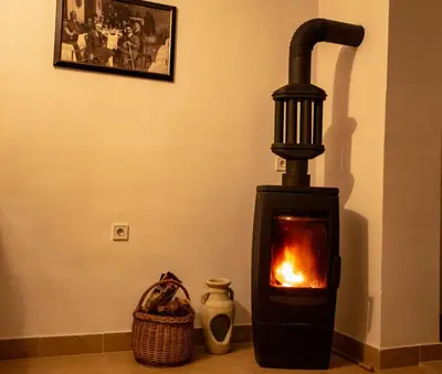 a black stove with a fire in a room at Уютная квартира в тени старого дуба in Becici