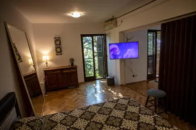 a living room with a tv on a wall at Уютная квартира в тени старого дуба in Becici