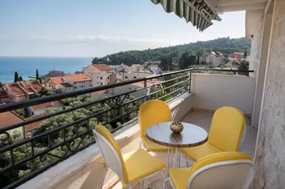 a balcony with a table and chairs and the ocean at Apartment Elena Petrovac in Petrovac na Moru