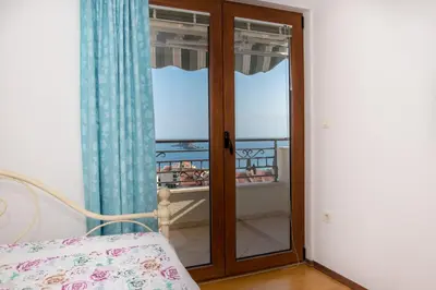 a room with a glass door with a balcony at Apartment Elena Petrovac in Petrovac na Moru