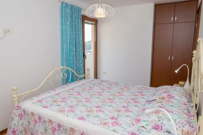 a bedroom with a bed with a floral bedspread at Apartment Elena Petrovac in Petrovac na Moru
