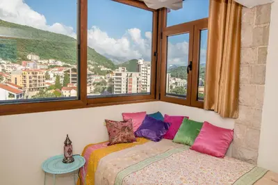 a bedroom with a bed with a view of a city at Apartment Elena Petrovac in Petrovac na Moru