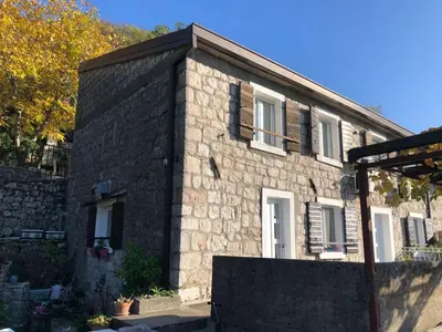 a stone house with a black brick at Family Stone house with magical Sea View in Kaluđerac