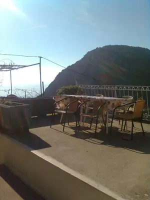 a table and chairs on a roof with a mountain at Family Stone house with magical Sea View in Kaluđerac