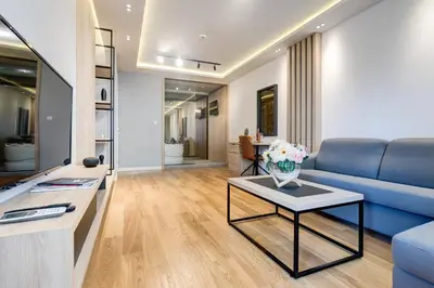 a living room with a blue couch and a table at Apart Compliment in Podgorica
