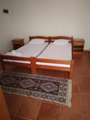a bedroom with a bed and a rug at Apartments Mitrović Podličak in Sveti Stefan