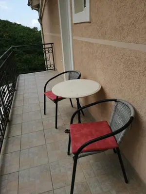 a table and two chairs sitting on a balcony at Apartments Mitrović Podličak in Sveti Stefan