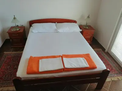 an orange and white bed with two night stands at Apartments Mitrović Podličak in Sveti Stefan