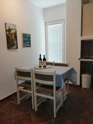 a dining room table with two bottles of wine on it at Apartments Mitrović Podličak in Sveti Stefan