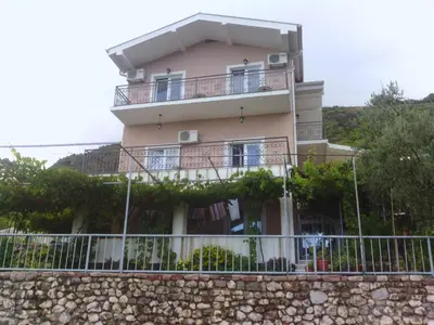 a building with balconies on top of a wall at Apartments Mitrović Podličak in Sveti Stefan
