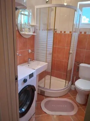 a bathroom with a washing machine and a sink at Apartments Mitrović Podličak in Sveti Stefan