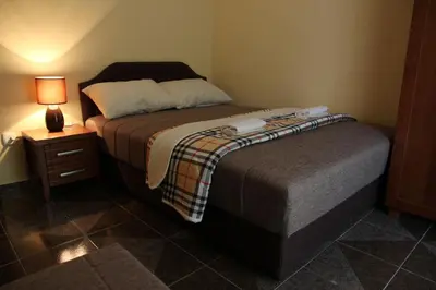 a bedroom with a bed and a night stand with a lamp at Guesthouse Civovic in Bar