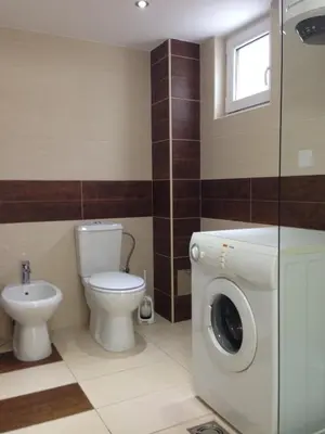 a bathroom with a toilet and a washing machine at Guesthouse Civovic in Bar