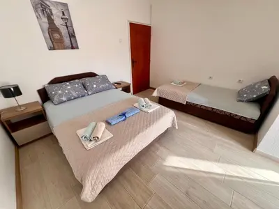 two beds in a room with shoes and towels on them at Guesthouse Civovic in Bar
