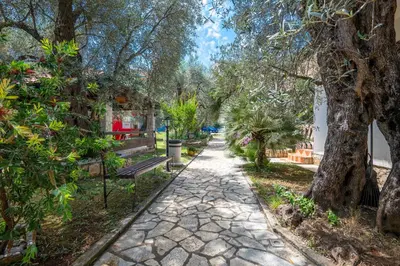 a walkway in a park with a bench and trees at President Bungalows and Apartments in Utjeha