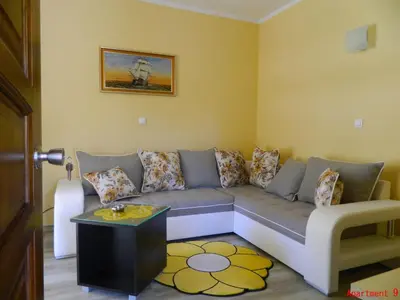 a living room with a couch and a table at President Bungalows and Apartments in Utjeha