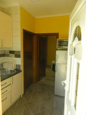 a kitchen with yellow walls and a white refrigerator at President Bungalows and Apartments in Utjeha