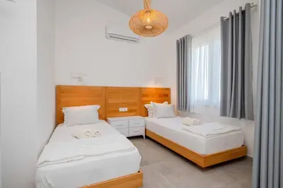 a bedroom with two beds and a chandelier at President Bungalows and Apartments in Utjeha