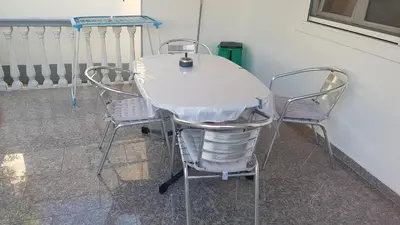 a white table and chairs sitting next to a wall at Studios Velika Plaža in Ulcinj