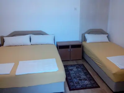 a room with two beds and a small table at Studios Velika Plaža in Ulcinj
