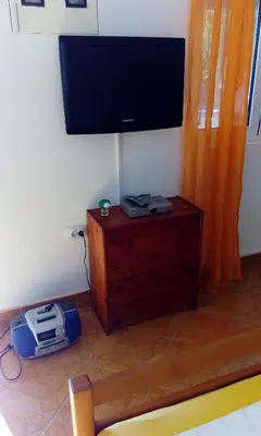 a flat screen tv on a wall with a wooden stand at Studios Velika Plaža in Ulcinj