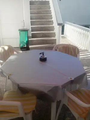 a table and chairs in a room with stairs at Studios Velika Plaža in Ulcinj