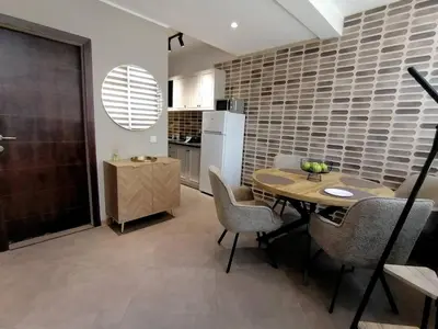 a kitchen and dining room with a table and chairs at Apartments Knežević in Ulcinj