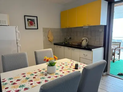 a kitchen with a table with a vase of flowers on it at Apartments Knežević in Ulcinj