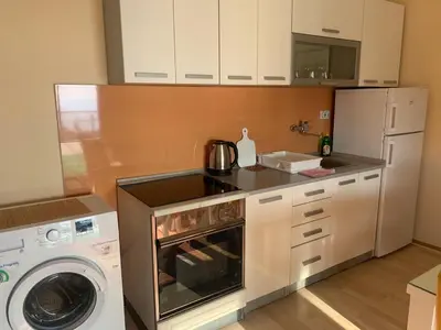a kitchen with a stove top oven next to a washer at Apartments Knežević in Ulcinj