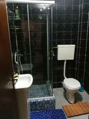 a bathroom with a shower and a toilet and a sink at Guest House Mudresa in Budva