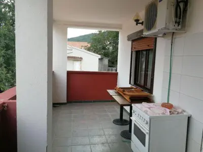 a kitchen with a stove and a table on a balcony at Guest House Mudresa in Budva