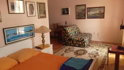 a living room with a bed and a chair at Guest House Mudresa in Budva