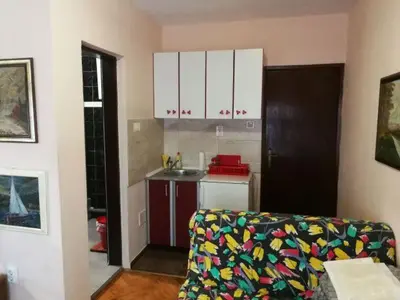 a living room with a couch and a kitchen at Guest House Mudresa in Budva