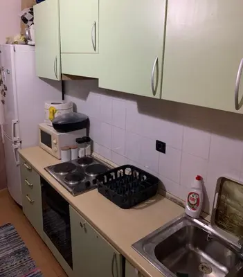 a kitchen with a sink and a stove and a microwave at Guest House Mudresa in Budva