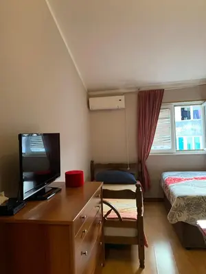a bedroom with a desk with a television and a bed at Guest House Mudresa in Budva