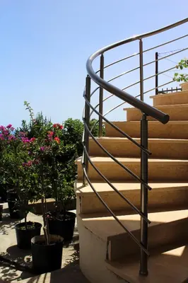 a staircase with a metal railing next to some plants at Apartments Olga in Ulcinj