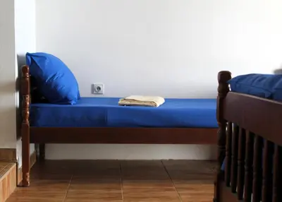 a bed with blue sheets and blue pillows on it at Apartments Olga in Ulcinj