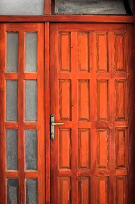 a red wooden door with glass panels on it at Apartments Olga in Ulcinj