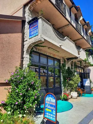 a sign in front of a building with a restaurant at Apartments Aleksandra Cetinje in Cetinje