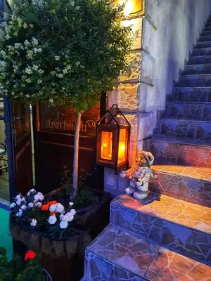 a lamp on the steps of a building with a tree at Apartments Aleksandra Cetinje in Cetinje