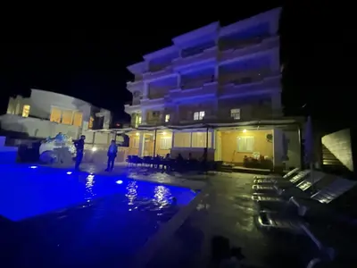 a man standing in front of a building at night at Queen Kodre Apartments in Ulcinj