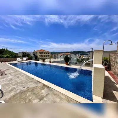 a swimming pool with a water fountain at Queen Kodre Apartments in Ulcinj