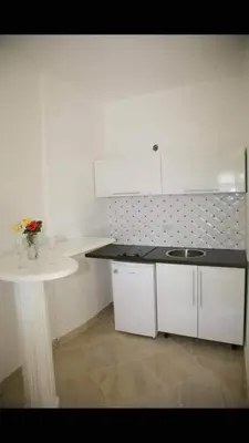 a white kitchen with a sink and a counter at Queen Kodre Apartments in Ulcinj